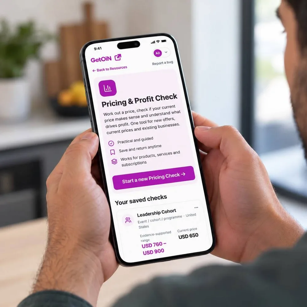Man holding a phone showing the GetOiN Pricing & Profit Check